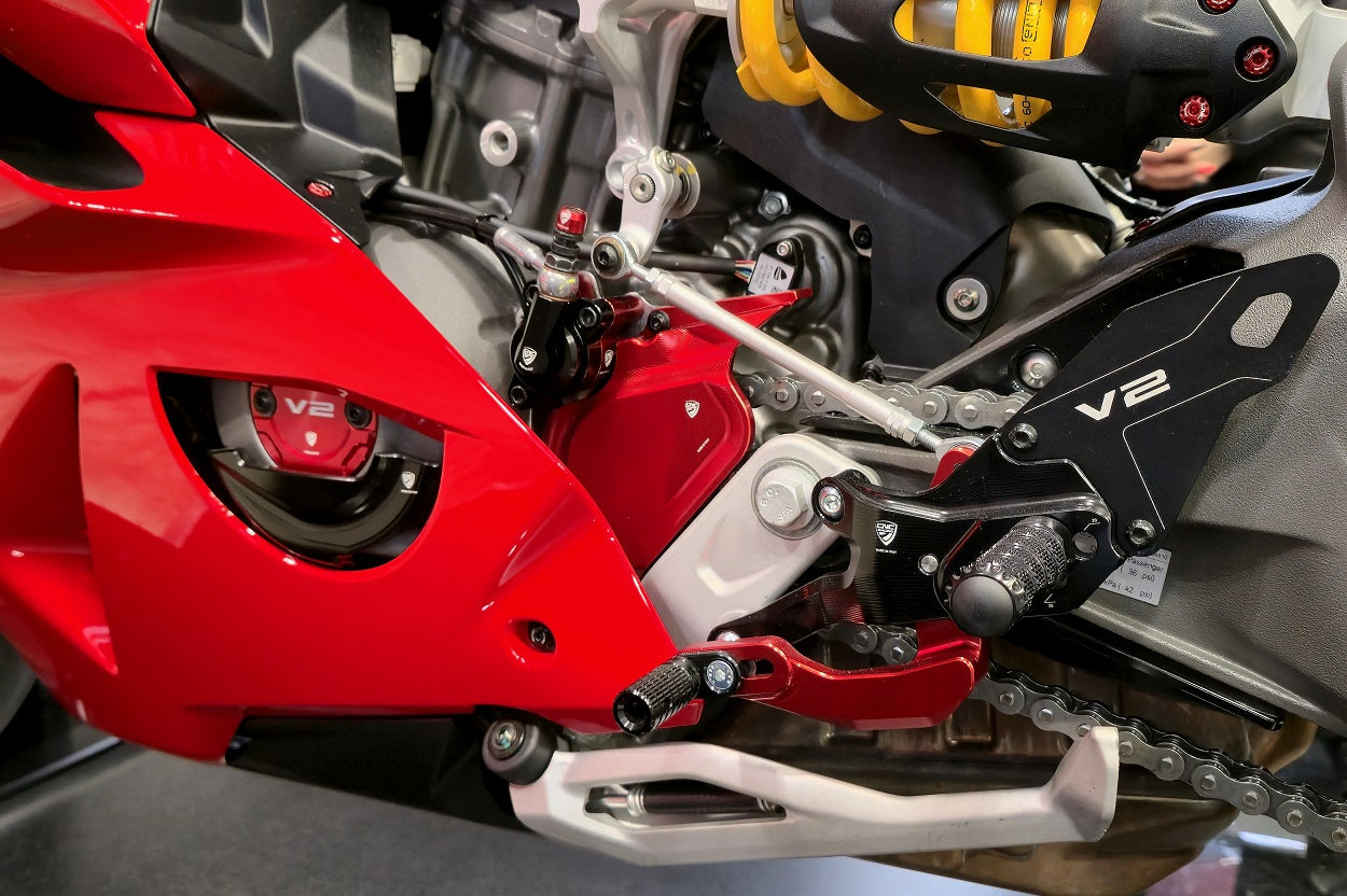 Detailbeeld van de rode CNC Racing voortandwielcover gemonteerd op Ducati Panigale V2, samen met andere CNC Racing componenten.